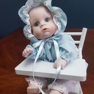 Porcelain baby doll in highchair